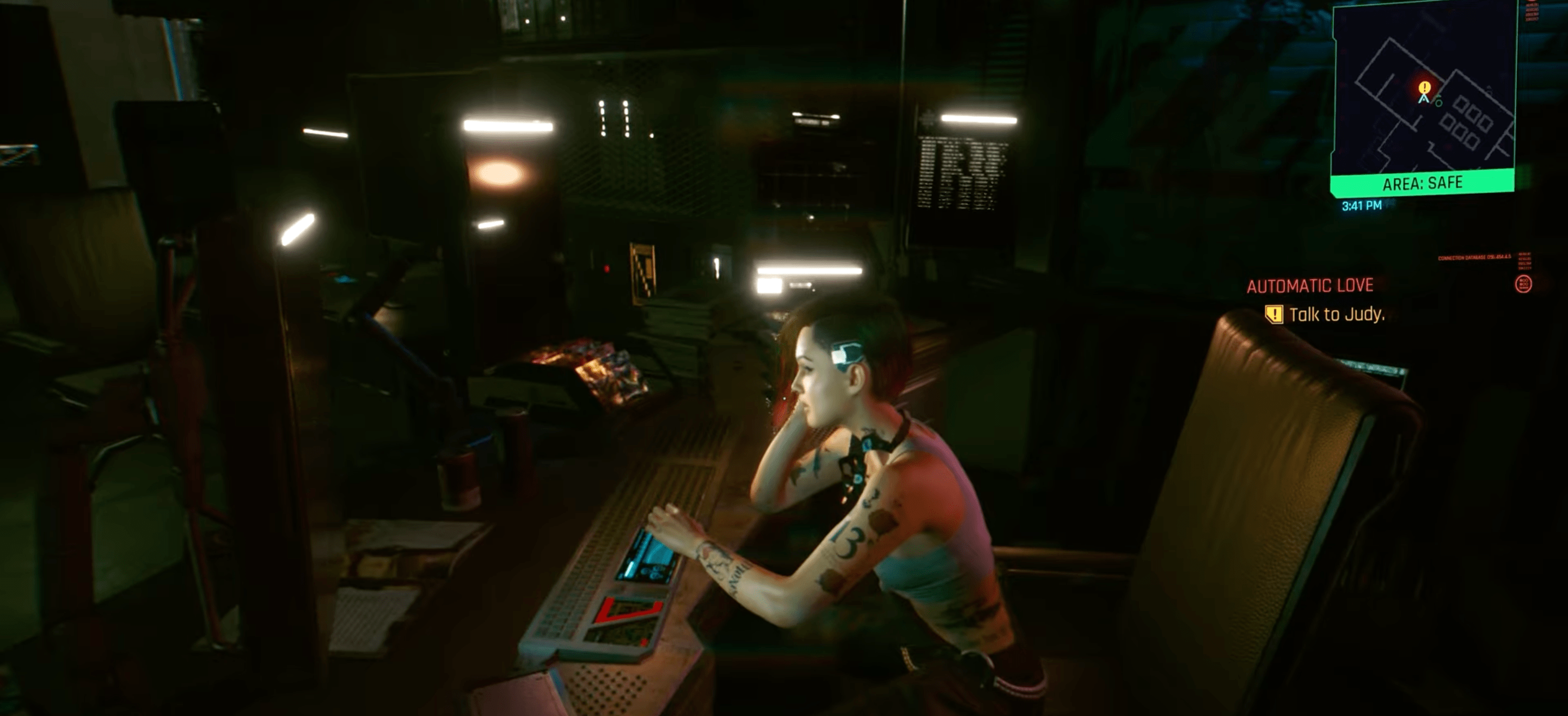 V talks to Judy, who sits at a table, in Cyberpunk 2077.