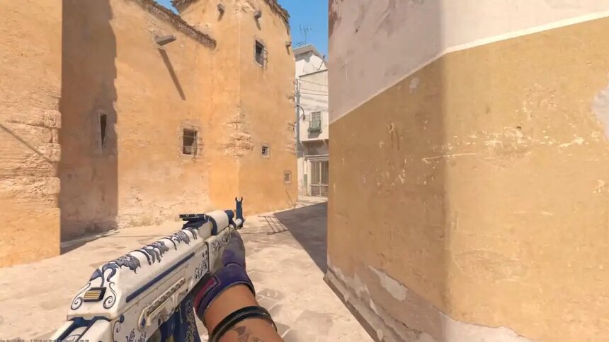 A player with an AK in their left hand on Dust 2 in CS2.